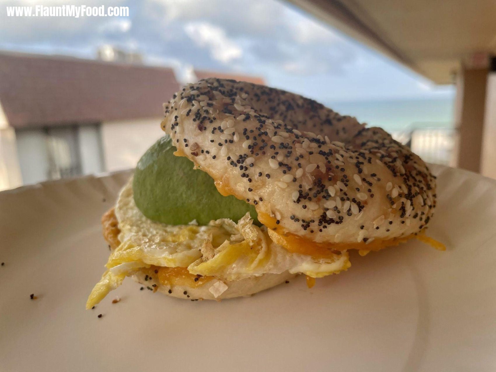 Bagel Egg and avocado BreakfastEnjoying a crisp fresh morning in the rain and eating an egg avocado and cheese bagel breakfast sandwich with coffee on the islands.