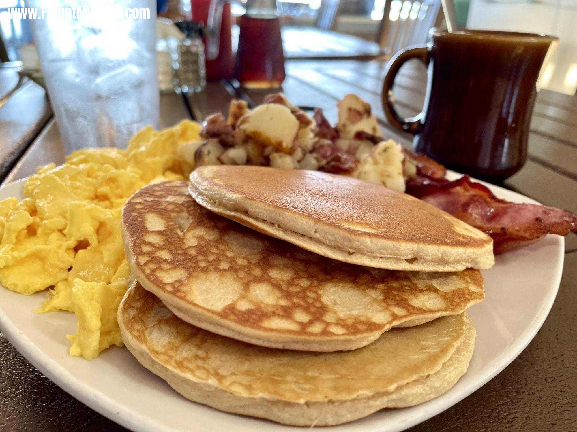 Three pancakes with two eggs home fries and bacon and coffee at Gulf Dr., Café on Anna Maria Island Florida