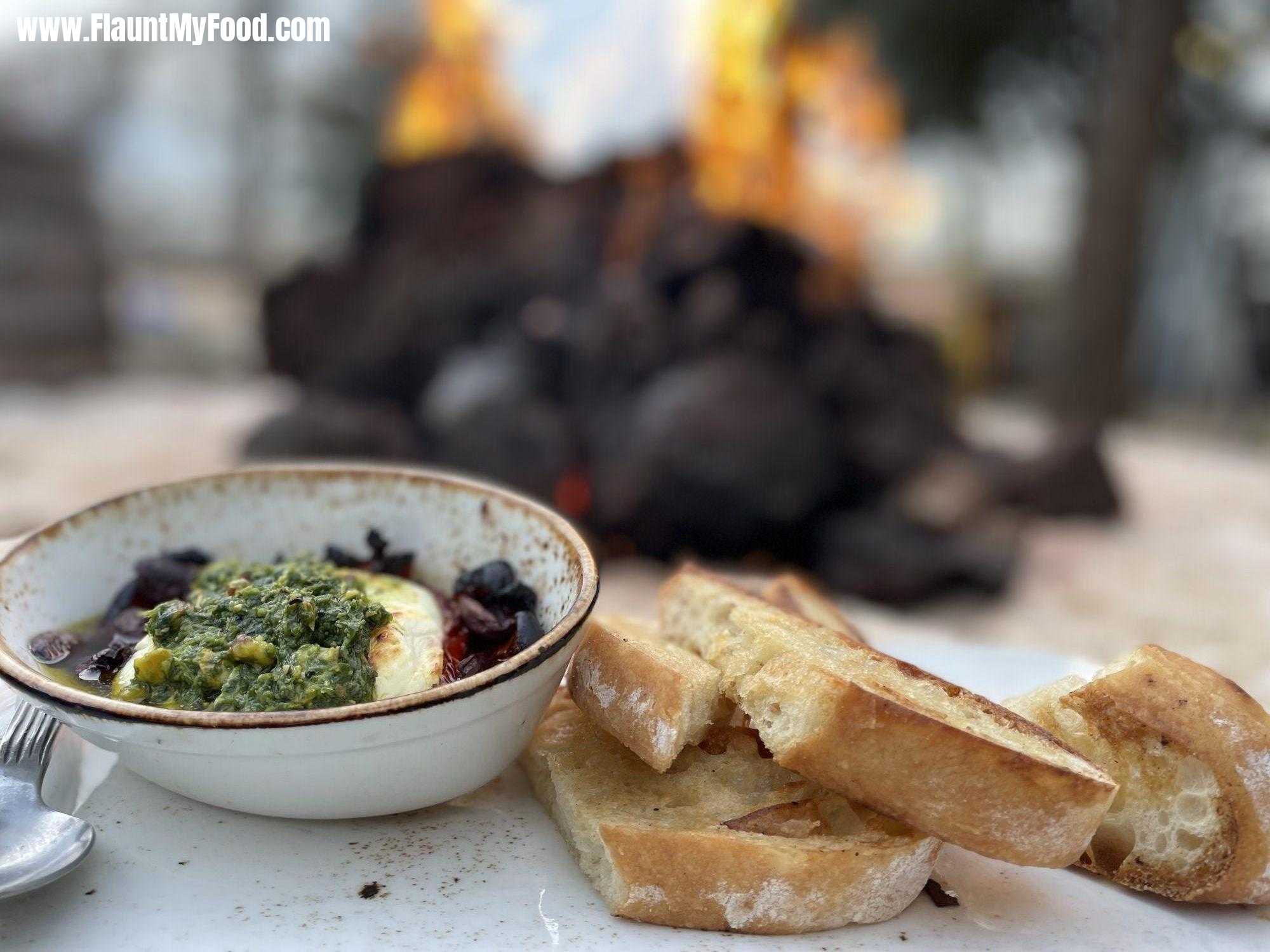 Baked goat cheese at press Cafe along the Trinity River in Fort Worth, TexasBaked goat cheese at press Cafe along the Trinity River near clear Fork Fort Worth, Texas toasted bread, delicious goat cheese with olives and a nice warm fire in the winter cold month of January 2024.